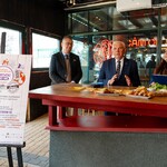 Uczestnicy konferencji siedzą przy blacie w restauracji.