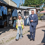 Zastępca prezydenta Rafał Rudnicki oraz kobieta idą przez targowisko.