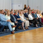 Goście wydarzenia siedzą na krzesłach.