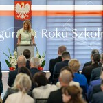 Kobieta stoi przed mównicą.