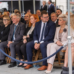 Przedstawiciele Miasta siedzą pod namiotem w trakcie uroczystości.