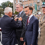 Prezydent Miasta Białegostoku przypina odznaczenie do marynarki mężczyzny.