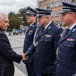 Prezydent Miasta Białegostoku podaje dłoń funkcjonariuszowi, obok stoją inni mundurowi.