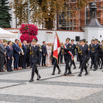 Poczet sztandarowy Straży Miejskiej idzie po Rynku Kościuszki, w tle stoją przedstawiciele Miasta.