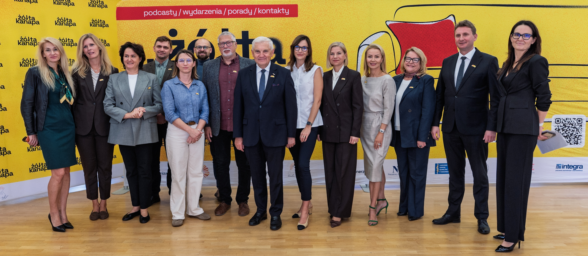 Grupa osób uczestnicząca w konferencji pozuje do wspólnego zdjęcia.