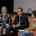 Trzy osoby siedzą na kanapie podczas konferencji prasowej.