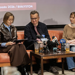 Uczestnicy konferencji siedzą na kanapie i udzielają wywiadu.