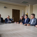 Uczestnicy zebrania siedzą w sali konferencyjnej przy stole.