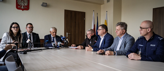 Uczestnicy zebrania siedzą w sali konferencyjnej przy stole.