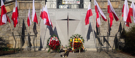 Flagi i kwiaty pod pomnikiem